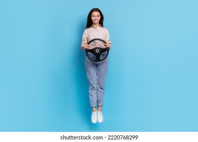 Photo Of Cheerful Positive Woman Hold Steering Wheel Jump Rejoice Buy New Car Vehicle Isolated On Blue Color Background