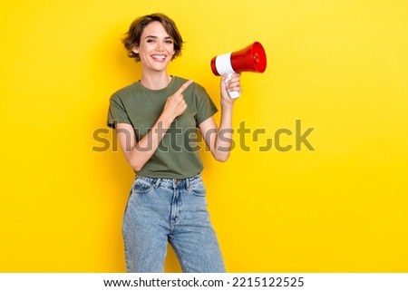 Photo of cheerful satisfied lady stand empty space wear stylish khaki outfit recommend cool device isolated on yellow color background