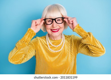 Photo of cheerful short hairdo senior lady hands eyewear wear blouse necklace isolated on blue color background - Shutterstock ID 2011831199