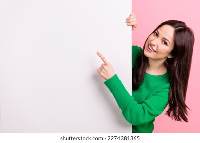 Photo of cheerful sweet woman wear green sweater pointing finger poster emtpy space isolated pink color background