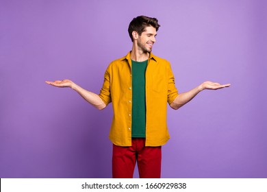 Photo Of Cheerful White Man Holding Two Objects Empty Space With Hands Smiling Toothily Isolated Violet Color Pastel Background