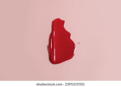 A photo of cherry-colored lip gloss. It has a glossy, glassy texture resembling a glass ball. The cosmetic texture is highly reflective, showcasing a high-gloss lip gloss. The image accurately capture