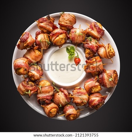 Photo of chicken medallion with bacon accompanied by sauce.