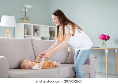 Photo Of Childish Cute Mother Dressed White T- Holding Hands Arms Child Lying Couch Smiling Inside Indoors Apartment Room