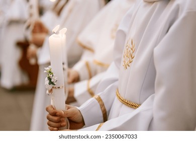 photo of children's hands receiving their first communion in a Catholic church, the priest blesses them