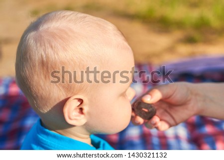 Photo of children's nape with sparse white hair, close-up. Mom feeds baby pastila.
