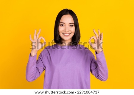 Photo of chinese young pretty woman wear purple shirt show double okey symbols good job alright isolated on yellow color background