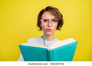 Photo of clever doubtful lady read book hold pencil wear eyeglasses blue pullover isolated yellow color background - Shutterstock ID 2052207524