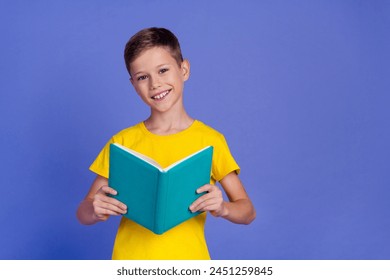 Photo of clever intelligent boy wear stylish yellow clothes read book fiction genre isolated on purple color background - Powered by Shutterstock