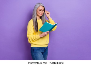 Photo Of Clever Pretty Lady Pensioner Dressed Pullover Arms Eyewear Reading Fiction Literature Isolated Purple Color Background