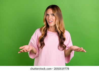 Photo Of Clueless Unhappy Young Woman Doubtful Shrug Shoulders No Idea Isolated On Green Color Background