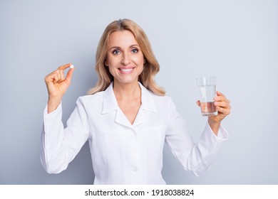 Photo of confident adorable mature lady doctor wear white coat holding pill water isolated grey color background - Powered by Shutterstock