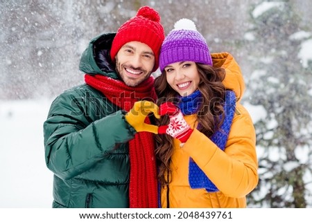 Photo of confident charming marriage couple wear windbreakers embracing walking snowy weather smiling outside park