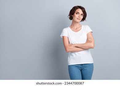 Photo of confident dreamy woman dressed white t-shirt arms crossed looking empty space isolated grey color background - Powered by Shutterstock