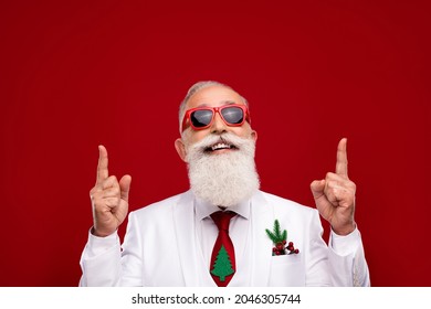 Photo Of Confident Funny Man Dressed White Christmas Costume Glasses Pointing Fingers Up Empty Space Isolated Red Color Background