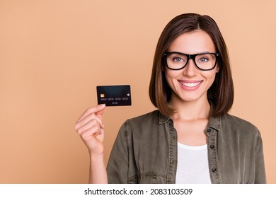 Photo Of Confident Lady Demonstrate Debit Card New Bank Promo Wear Specs Khaki Shirt Isolated Beige Color Background