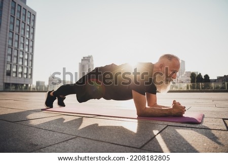 Photo of confident motivated old man stand elbow plank endurance stamina trainer wear t-shirt urban town outdoors