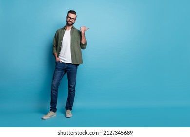 Photo of confident promoter guy indicate thumb empty space wear green shirt jeans isolated blue color background - Shutterstock ID 2127345689