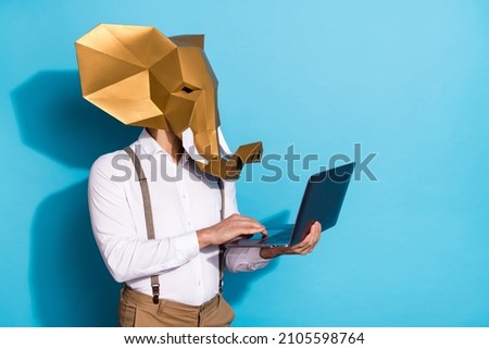 Photo of confident serious guy dressed animal mask typing device empty space isolated blue color background