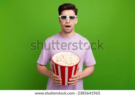 Photo of confused funny man with brunet hair dressed purple t-shirt in 3d glasses astonished staring isolated on green color background