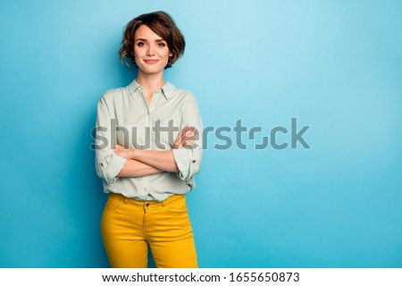 Photo of cool attractive business lady short hairstyle friendly smiling responsible person arms crossed wear casual green shirt yellow pants isolated blue color background