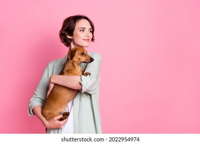 Photo Of Cool Young Lady Hug Dog Look Empty Space Wear Grey Green Jacket Isolated On Pink Color Background