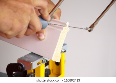 Photo Of Coping Saw Being Used On Piece Of Trim