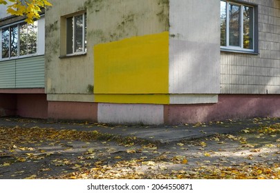 Photo Of The Corner Of A House With Yellow Paint On The Wall On The Street With Fallen Yellow Maple Leaves.