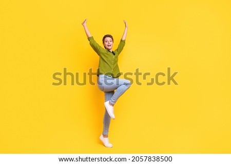 Photo of crazy funky cheerful positive lady dance raise hands wear green shirt isolated yellow color background