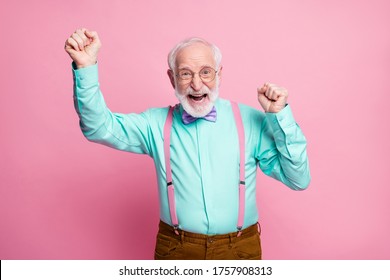 Photo Of Crazy Funky Grandpa Raise Fists Celebrating Pensioner Party Beginning Ecstatic Mood Wear Specs Mint Shirt Suspenders Violet Bow Tie Pants Isolated Pink Pastel Color Background