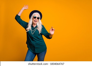 Photo Of Crazy Granny Lady Young Spirit Music Lover Senior Party Cool Look Dancing Youngster Moves Wear Green Shirt Sun Specs Pearls Necklace Jeans Cap Isolated Yellow Color Background