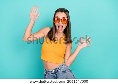 Photo of crazy positive funky happy woman raise hands wear sunglass funny face isolated on teal color background