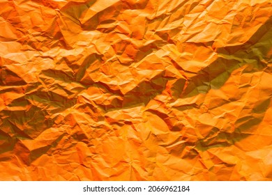 Photo of crumpled wrinkled orange office paper lit with red light, background texture - Shutterstock ID 2066962184