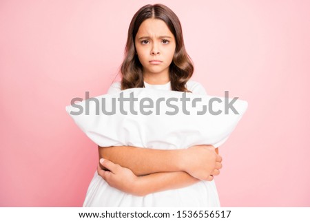Photo of crying sad hispanic unhappy preteen with disappointed facial expression having dreamed badly isolated pastel color background hugging her pillow