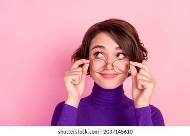 Photo of curious brunette young lady hold spectacles look empty space wear violet turtleneck isolated on pink background - Shutterstock ID 2037145610
