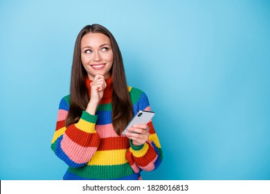 Photo of curious woman addicted blogger use smartphone think thoughts look copyspace touch fingers chin decide what texting typing wear rainbow style sweater isolated blue color background - Powered by Shutterstock