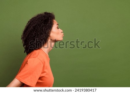 Photo of cute adorable lady dressed orange t-shirt kissing empty space isolated khaki color background