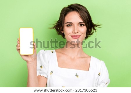 Photo of cute adorable woman dressed white blouse showing apple samsung iphone device empty space isolated green color background