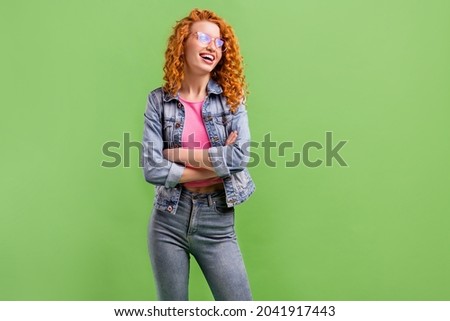 Photo of cute charming lady dressed denim clothes glasses smiling arms folded looking empty space isolated green color background