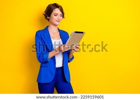 Photo of cute charming lady dressed blue blazer working typing modern device empty space isolated yellow color background