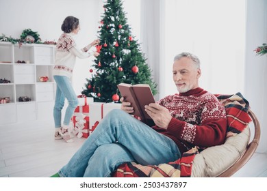 Photo of cute couple aged lady hang toys man read book wear sweater jeans socks at home - Powered by Shutterstock