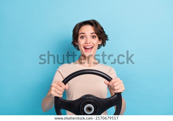 Photo of cute
excited lady dressed beige t-shirt driving vehicle open mouth
isolated blue color
background