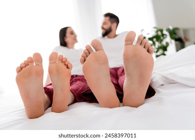 Photo of cute funky couple wear white t-shirts sititng bed showing feet indoors apartment bedroom - Powered by Shutterstock