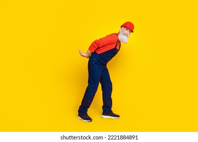 Photo Of Cute Funny Age Man Workwear Overall Red Hard Hat Holding Arms Big Empty Space Isolated Yellow Color Background