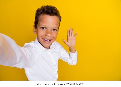 Photo Of Cute Funny Boy Remote Distance Lesson Hand Wave Classmates Friends Say Hi Empty Space Isolated On Yellow Color Background