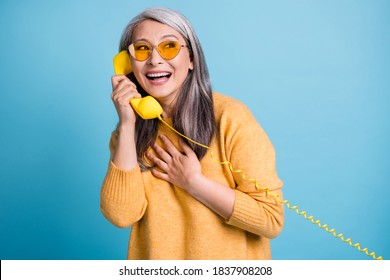 Photo Of Cute Genuine Dreamy Funny Aged Lady Receiving Call From Friend Get Compliment Funny Conversation Laughing Jokes Wear Sunglass Yellow Jumper Vibrant Blue Color Background