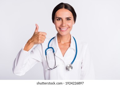 Photo of cute good mood young woman physician wear formal coat showing thumb up smiling isolated white color background