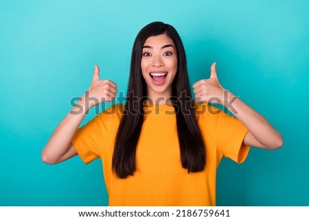 Photo of cute gorgeous adorable girl with straight hairdo yellow t-shirt screaming yes showing thumb up isolated on teal color background