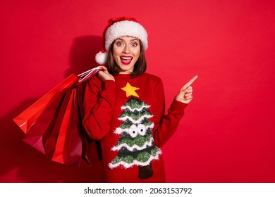 Photo of cute impressed woman wear ornament sweater holding new year shopping bags modern device isolated red color background - Powered by Shutterstock