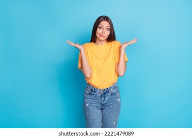 Photo of cute nice puzzled woman dressed yellow outfit shrugging shoulders no answer excuse isolated on blue color background